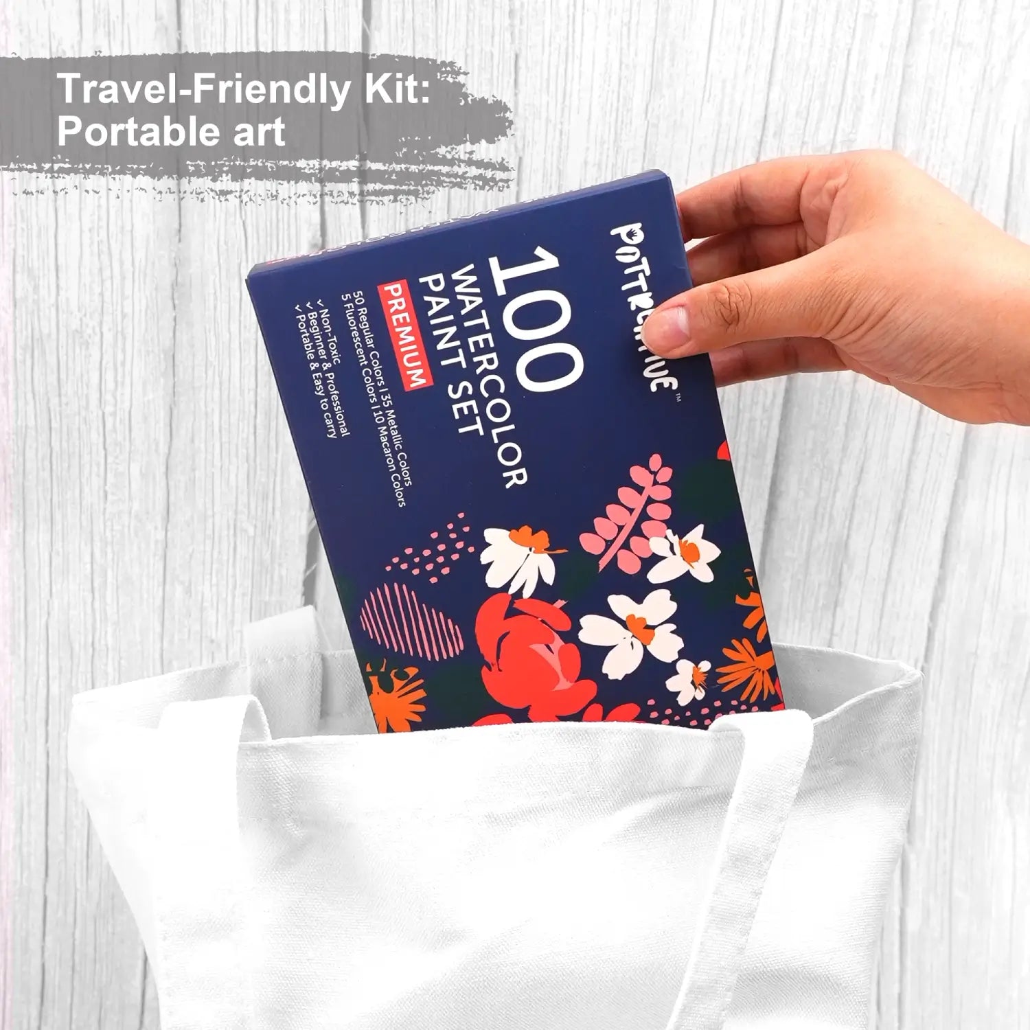 The compact box of the 100 Colors Watercolor Paint Set being placed into a tote bag, showcasing its travel-friendly and portable design for artists.